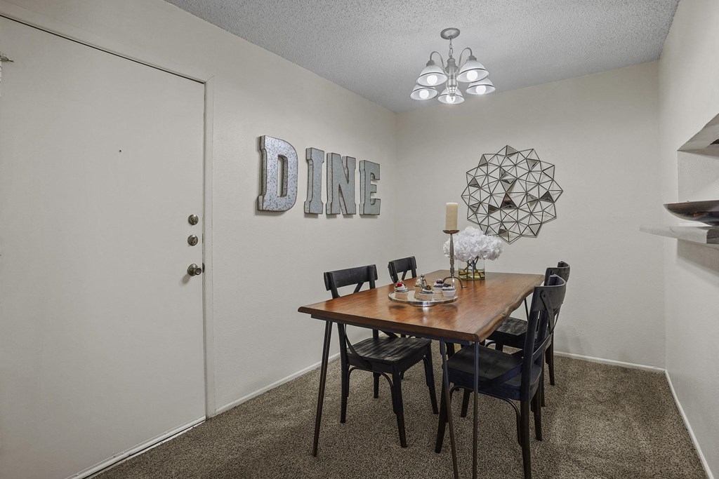 A dining room with a wooden table and chairs.