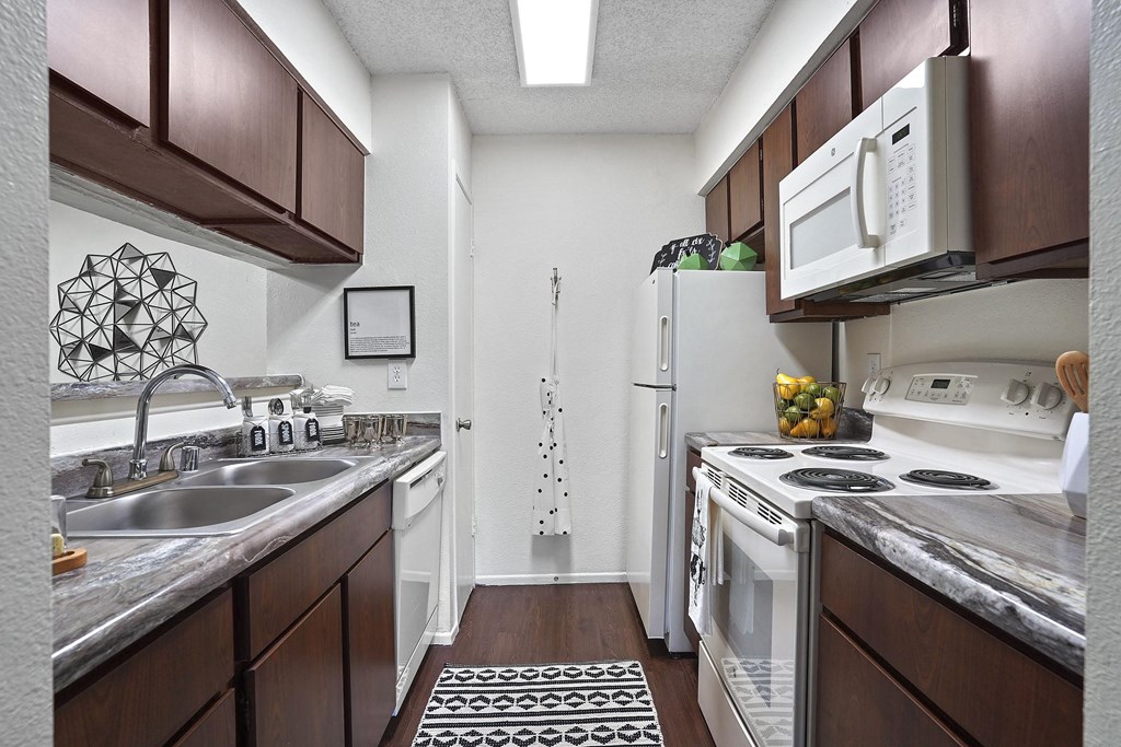 A kitchen with a white fridge and a white microwave.