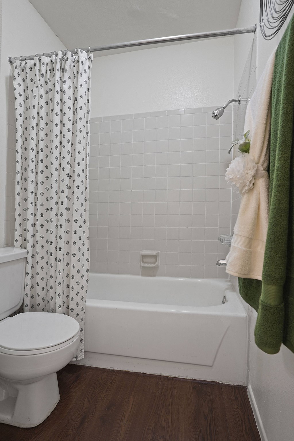 A white toilet sits next to a white bathtub in a bathroom.