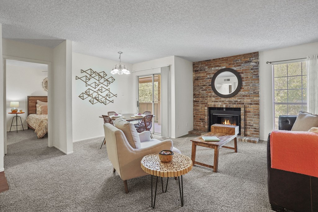 A living room with a fireplace and a brick wall.