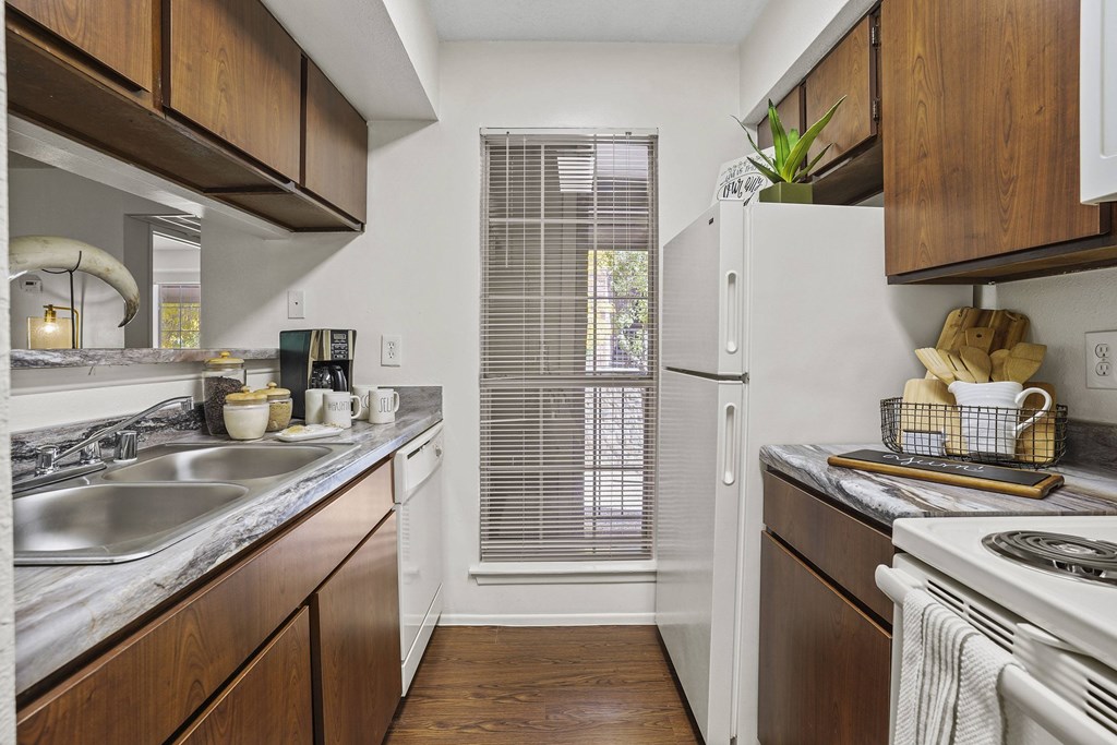 A kitchen with wooden cabinets and a white refrigerator.