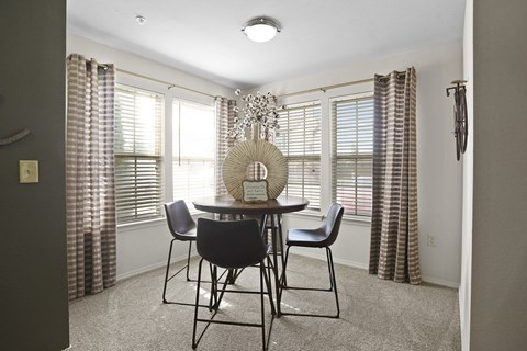 A dining room with a round table and chairs.