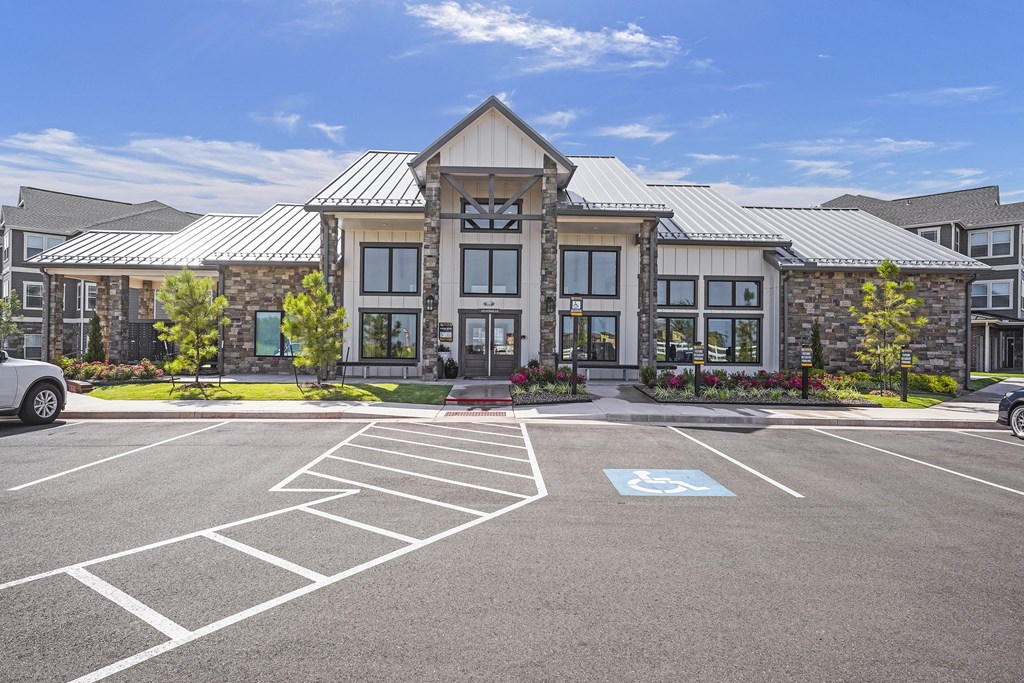A parking lot with a building in the background and a handicap parking spot.