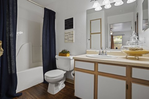 A white toilet with a blue curtain in a bathroom.