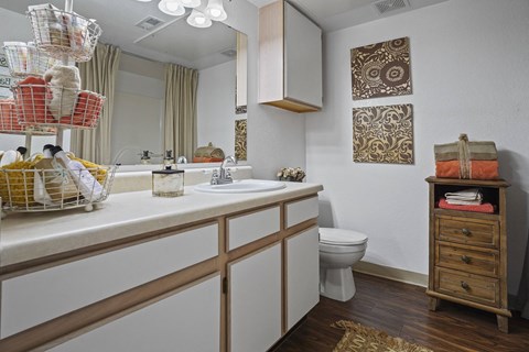 A bathroom with a white counter and a brown cabinet.