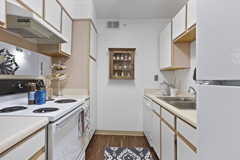 A kitchen with white appliances and wooden cabinets.