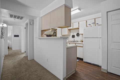 A kitchen with white appliances and wooden cabinets.