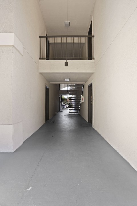 A long, narrow hallway with a balcony on the second floor.