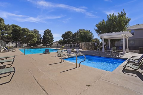 A pool area with chairs and a gazebo.