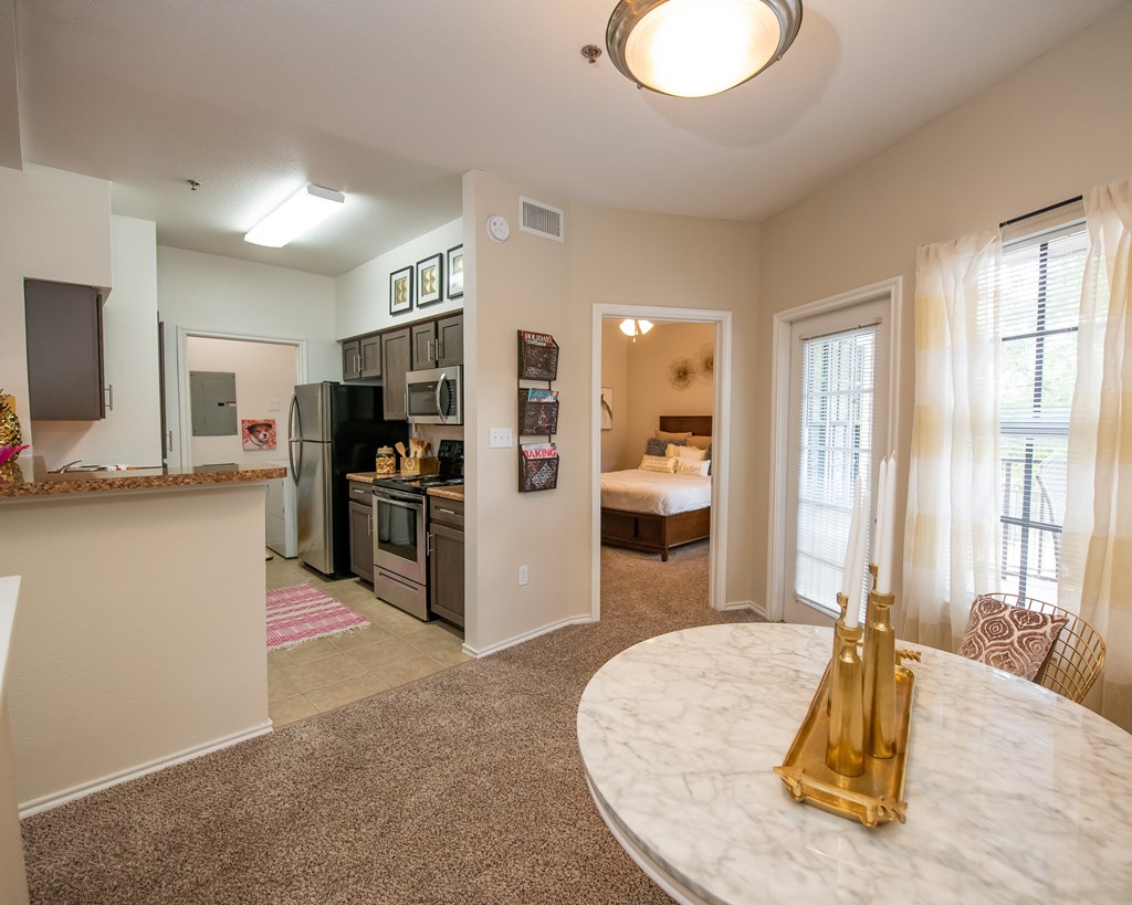 A kitchen with a refrigerator, microwave, and oven.