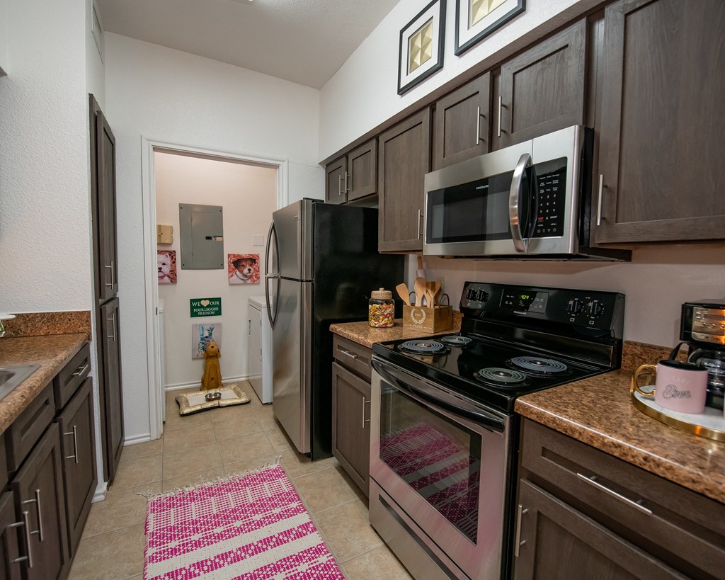 A kitchen with brown cabinets and a black stove top oven.