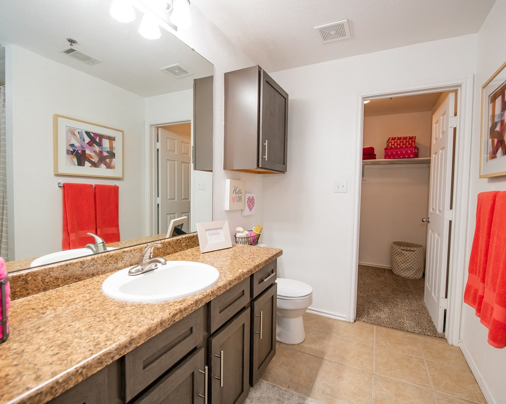 A bathroom with a brown counter top and a white sink.