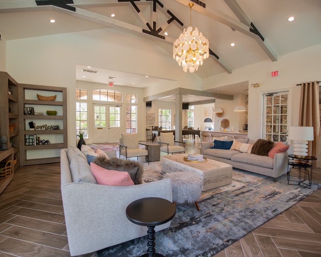 A living room with a grey couch and a chandelier.