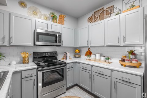 A kitchen with white cabinets and a black stove top.