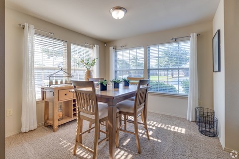 A dining room with a table and chairs.