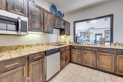A kitchen with wooden cabinets and a granite countertop.