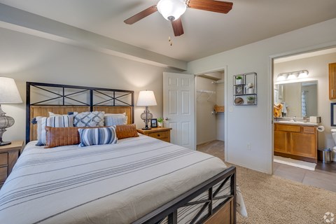 A bedroom with a large bed and a ceiling fan.
