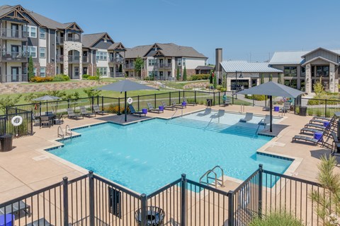 A large swimming pool surrounded by a black fence.