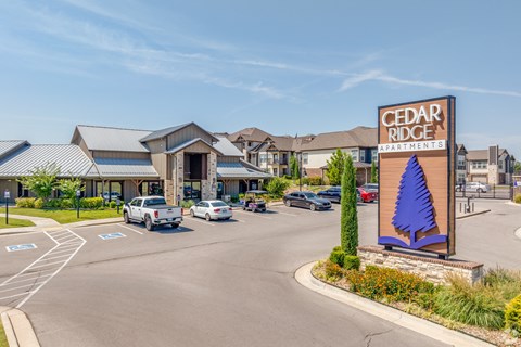 Cedar Ridge Apartments sign in front of a parking lot.