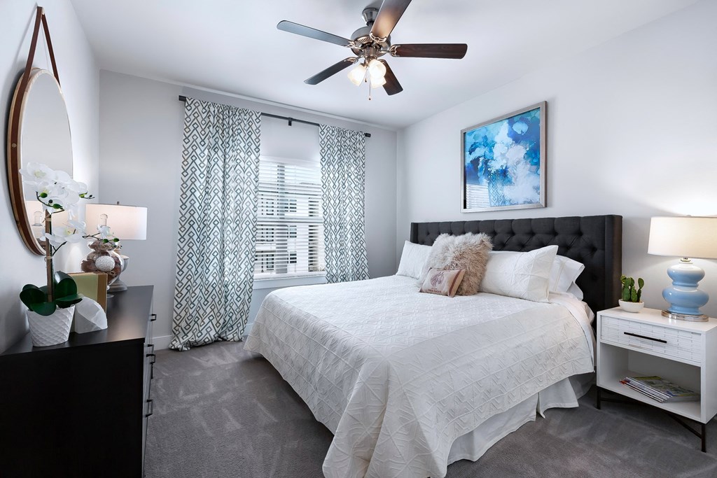 a bedroom with a bed and a ceiling fan