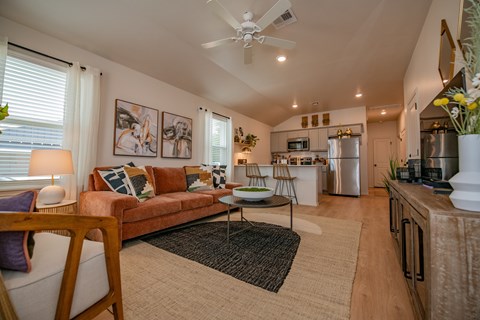 A living room with a couch, a coffee table, and a ceiling fan.