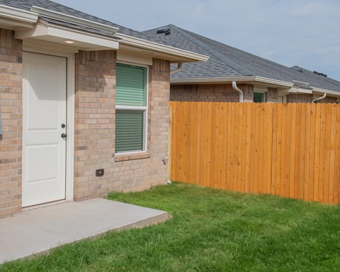 A house with a white door and a wooden fence.