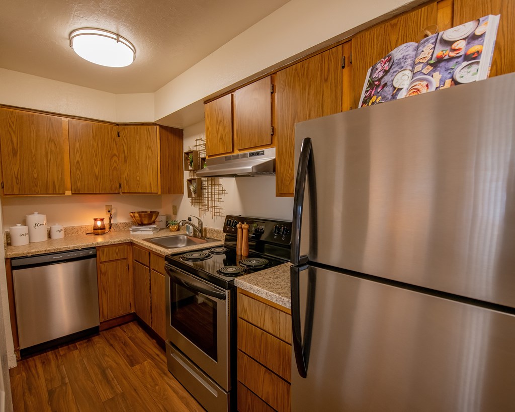 A kitchen with a stainless steel refrigerator, oven, and dishwasher.