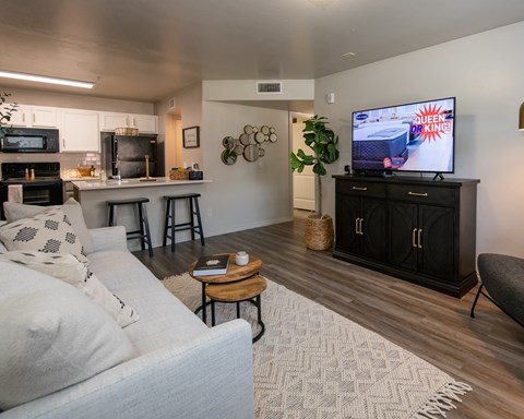 A living room with a white couch and a television displaying a game.