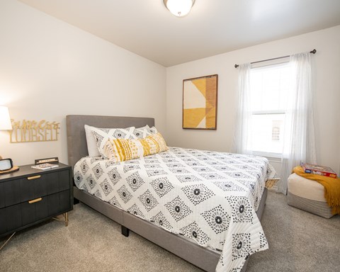 A bedroom with a large bed and a painting on the wall.