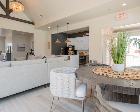 A modern kitchen with a dining area and a white sofa.