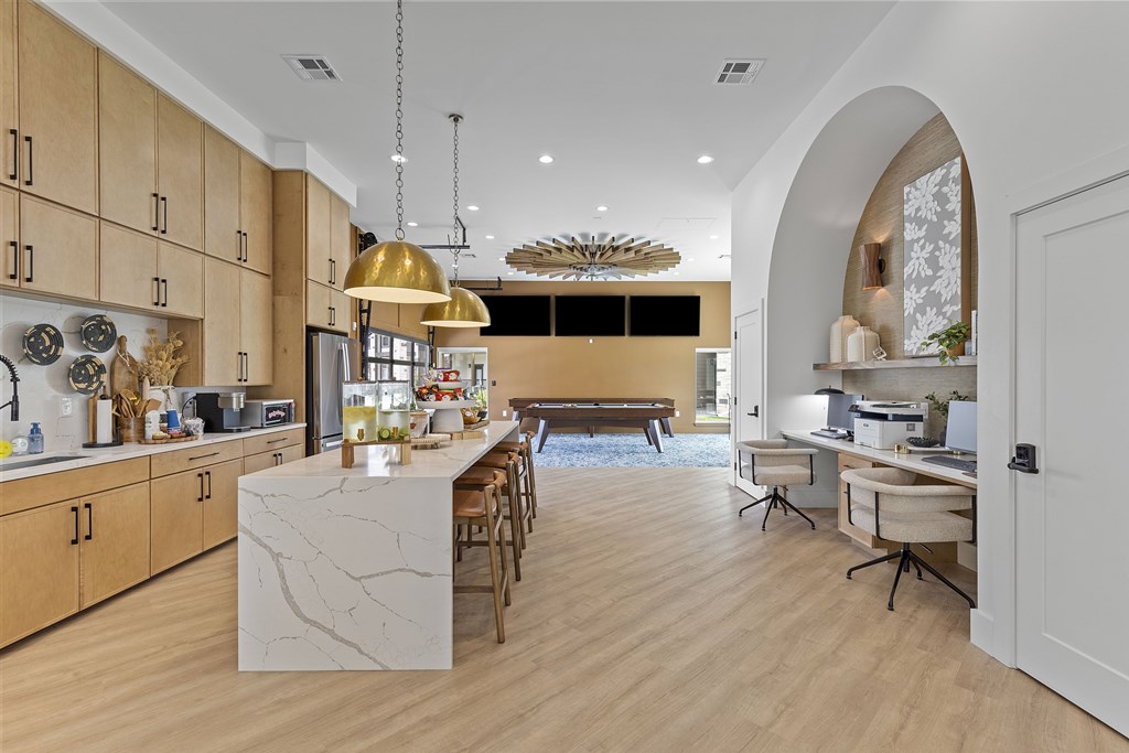 A modern kitchen with wooden cabinets and a marble island.