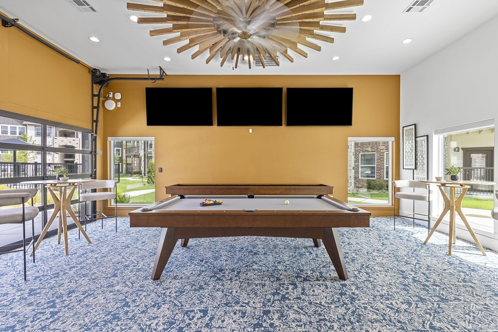 A billiard table is in the middle of a room with a pool table.