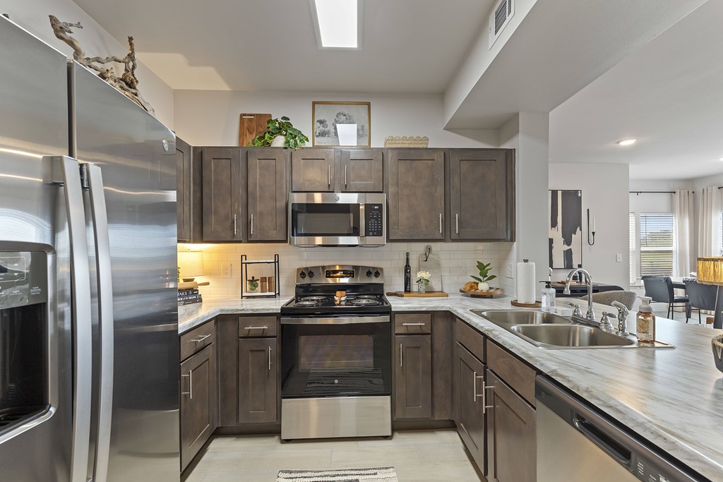 A modern kitchen with stainless steel appliances and wooden cabinets.