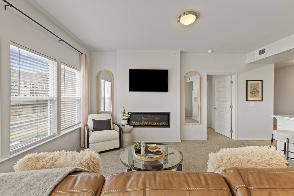 A living room with a fireplace and a flat screen TV mounted on the wall.