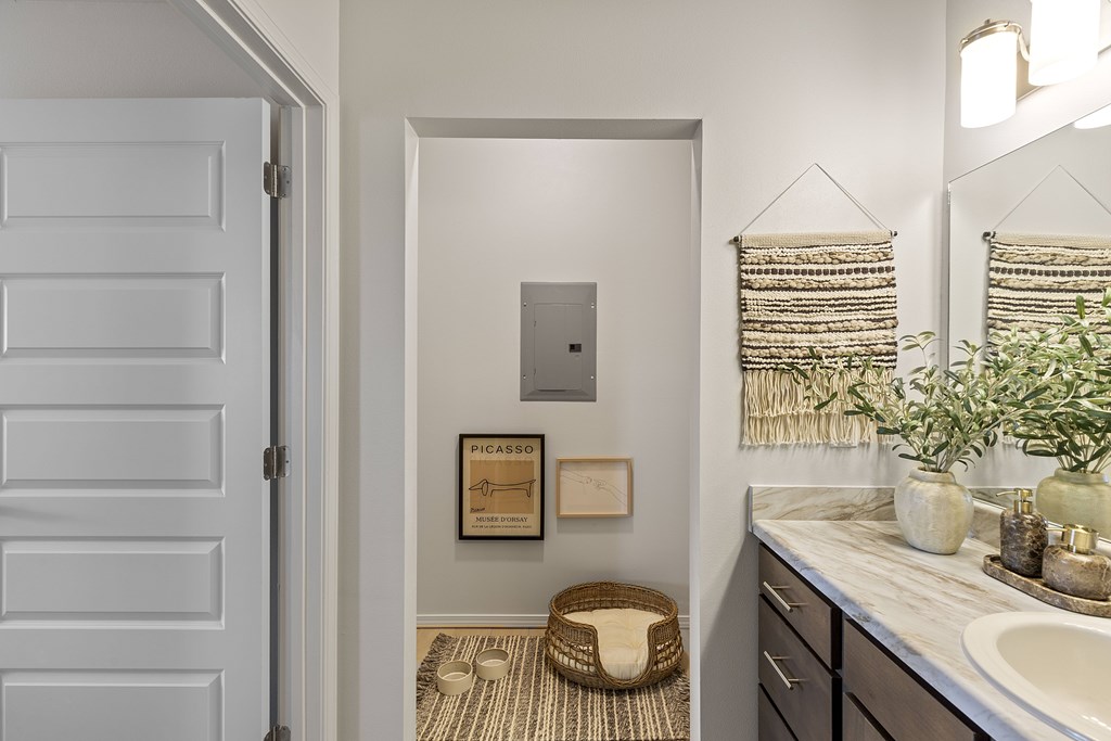 A bathroom with a white door and a mirror above a sink.