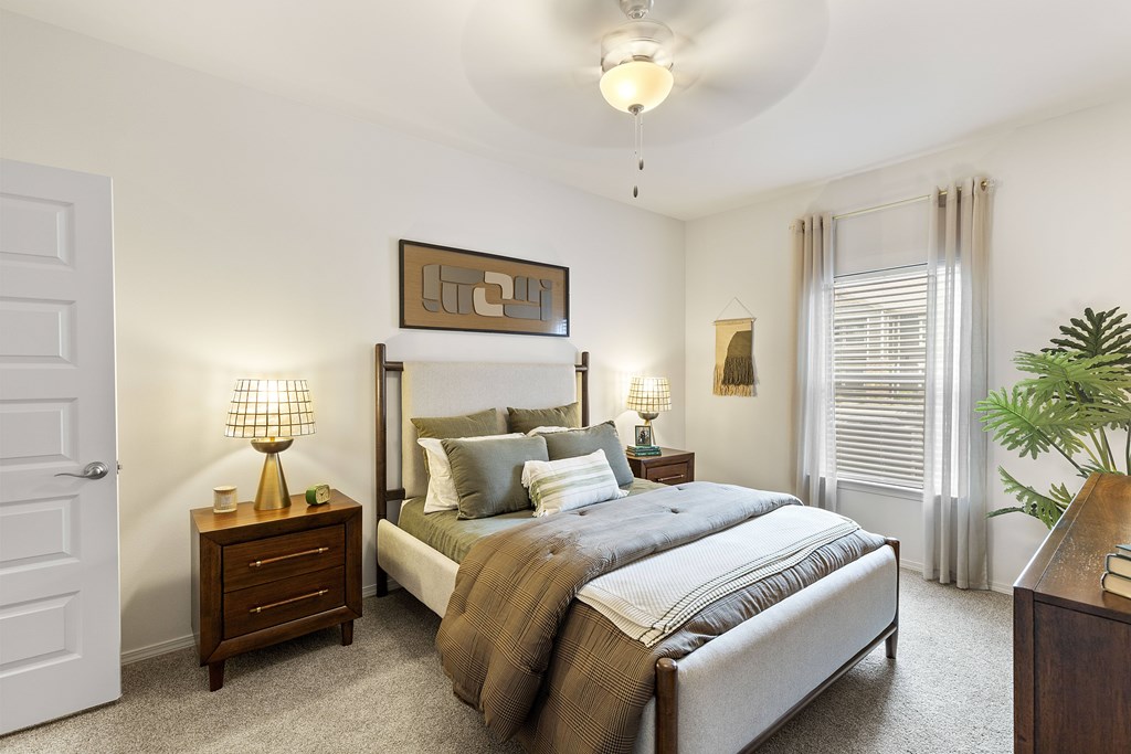 A bedroom with a large bed and a painting above it.