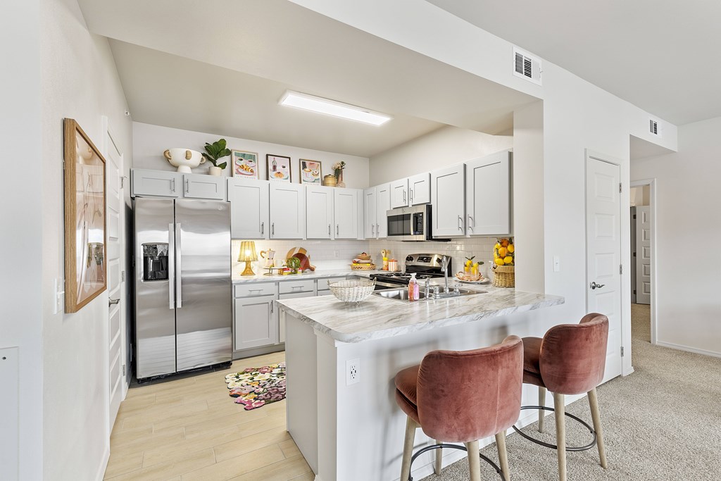 A kitchen with a white countertop and a refrigerator.