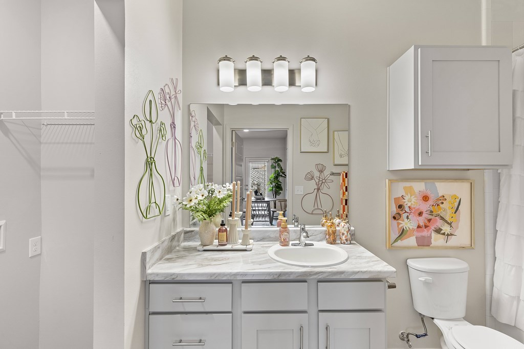 A bathroom with a marble countertop and a white toilet.