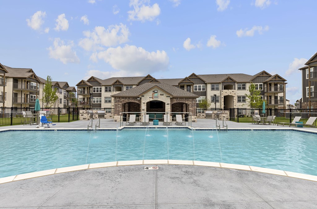 A large swimming pool in front of a row of houses.