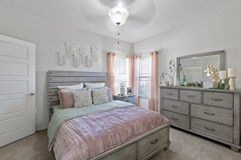 A bedroom with a bed, dresser, and mirror.