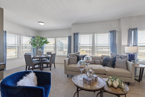 A living room with a blue armchair and a grey couch.