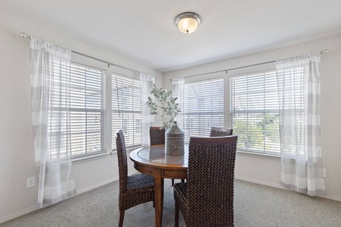A dining room with a table and chairs.