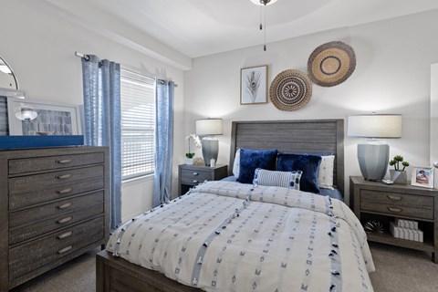 A bedroom with a large bed and a dresser.