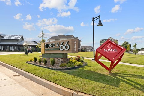 A sign for Ridge at 66 and a red sculpture of a house with the words CASE Associates on it.