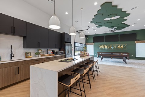 A modern kitchen with a long island and bar stools.