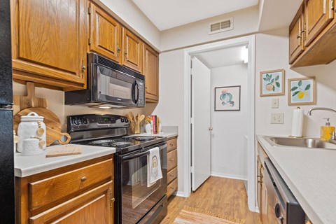 A kitchen with wooden cabinets and a black stove top oven.