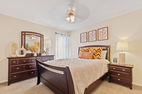 A bedroom with a bed, dresser, and mirror.