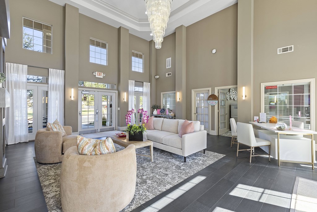 A large, well-lit lobby with a variety of seating options and a chandelier hanging from the ceiling.