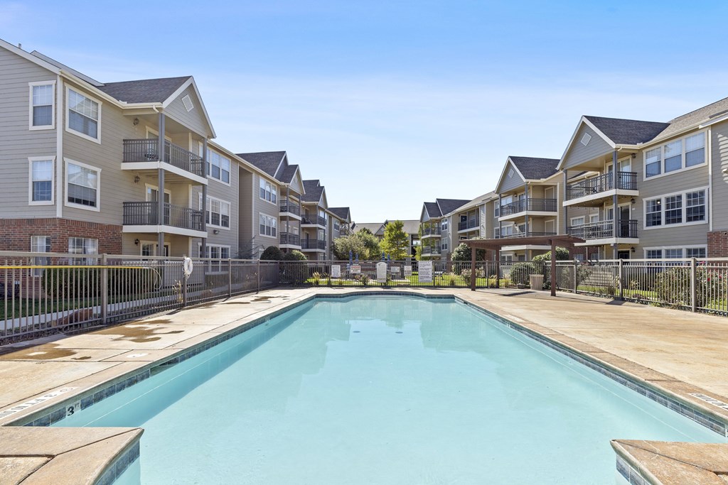 A swimming pool in front of apartment buildings.
