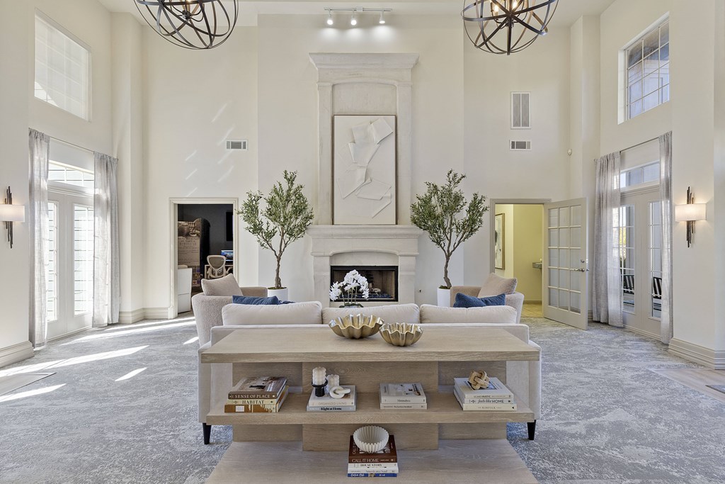 A large, elegant living room with a fireplace and a chandelier.